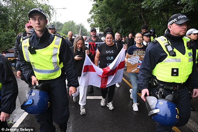 Police give an escort to protesters marching through Epping as they aim to avoid a repeat of the kind of unrest that happened during a previous protest on July 17
