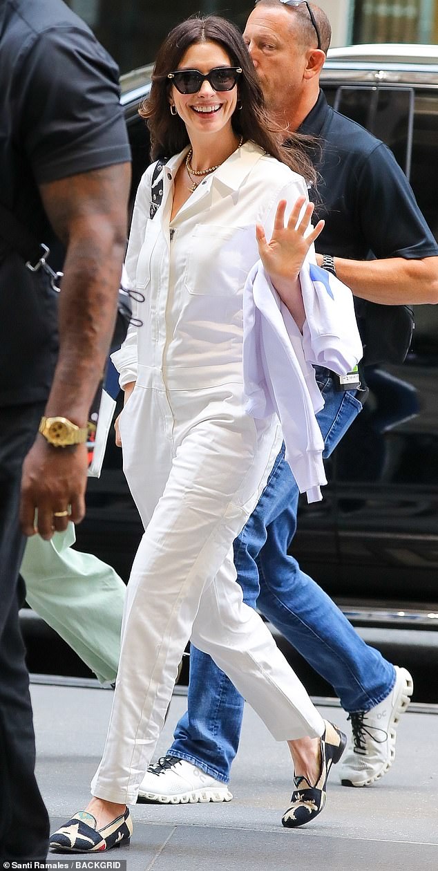 She additionally slipped into a pair of black and gold-colored flats while a black purse was placed over her right shoulder