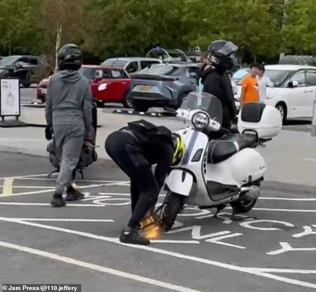 A masked gang member uses an angle grinder to steal a bike at an IKEA car park in Croydon this week. Shock figures reveal Britain is in the grip of a 'retail crime epidemic'