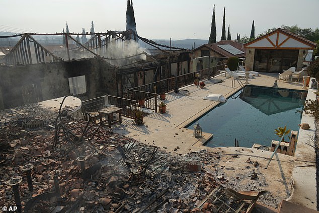 The updated advice comes as at least 39 square miles has been razed to the ground in a wine¿producing region north of the city of Limassol, near popular holiday hotspots. Pictured: Burned houses are seen in Souni village, Cyprus on Thursday, July 24, 2025