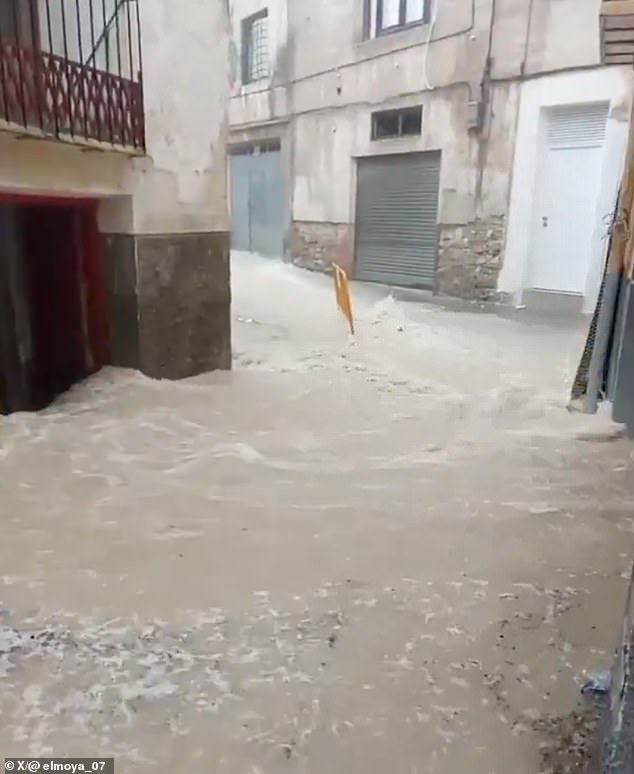 Dramatic footage shows dirty water gushing down streets and into houses in Murcia, southeastern Spain