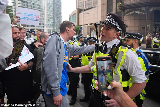 Protesters and police outside the Britannia International Hotel in Canary Wharf on July 23