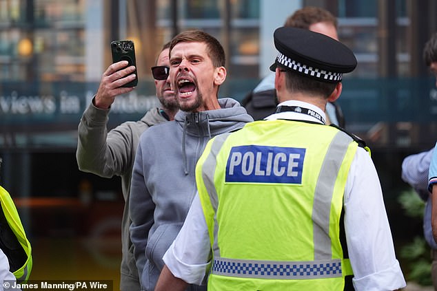 A protester shouts to a group of counter-protesters outside the Britannia International Hotel in Canary Wharf on July 23