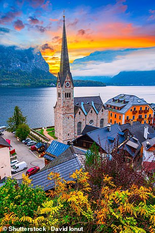 Scenic morning view of the old town church and lake in the alpine village of Hallstatt, Austria