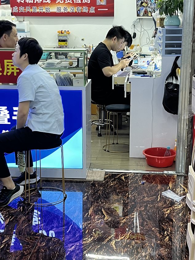 Staff in a mobile phone repair shop in China working on phones that may have been snatched from the streets of London
