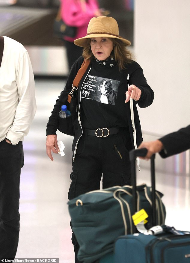 Blair cut a low-key figure in a black tee, straw hat and high waisted trousers as she wheeled her suitcase at LAX