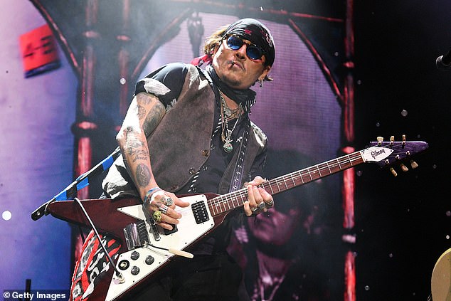 Depp puffed on a cigarette while rocking out on stage
