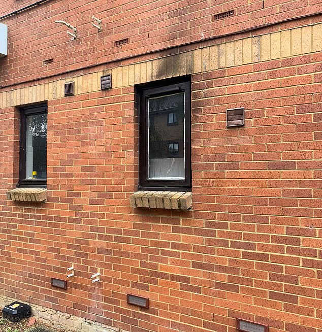 Pictured: The brick wall around one of the windows on Roger's flat which has been charred by the fire
