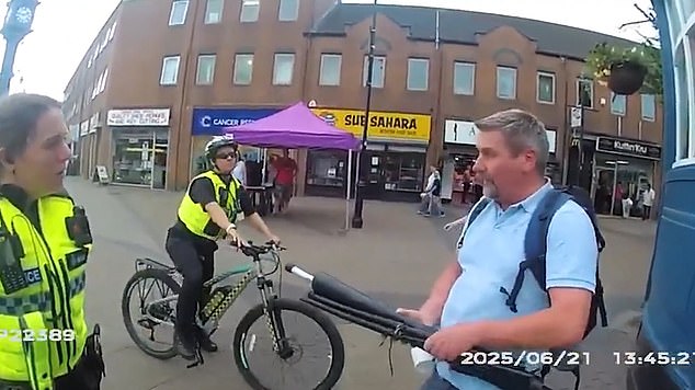 Following his continued refusal to provide his details, Mr Steele is then led away to a police car. The long-standing preacher is pictured here rolling up his sign