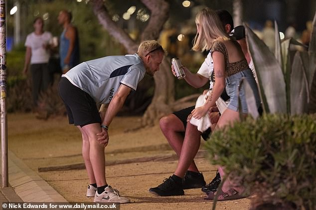 Pictured: A group of holidaymakers drinking from beer cans. Street drinking was made illegal in parts of Majorca including Arenal and Magaluf last year