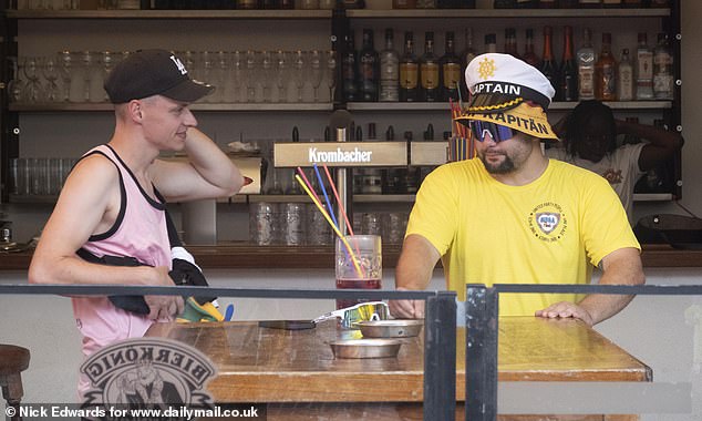 Holidaymakers drinking at Bamboleo. One of the men is seen wearing a 'Kapitan' hat, which is German for captain