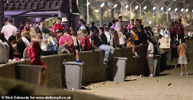 The beachfront was filled with people sitting by the side while eating their post-night out food