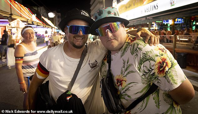 Two drunk German men pose for a photo during a night on the strip
