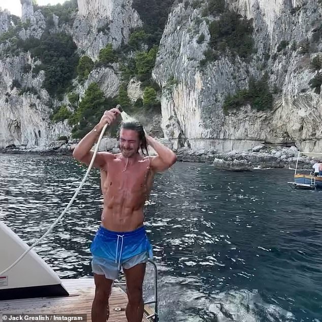 In one holiday snap, Jack put his muscular physique on display as he went shirtless in a pair of blue board shorts while using the outdoor shower on board a luxury yacht