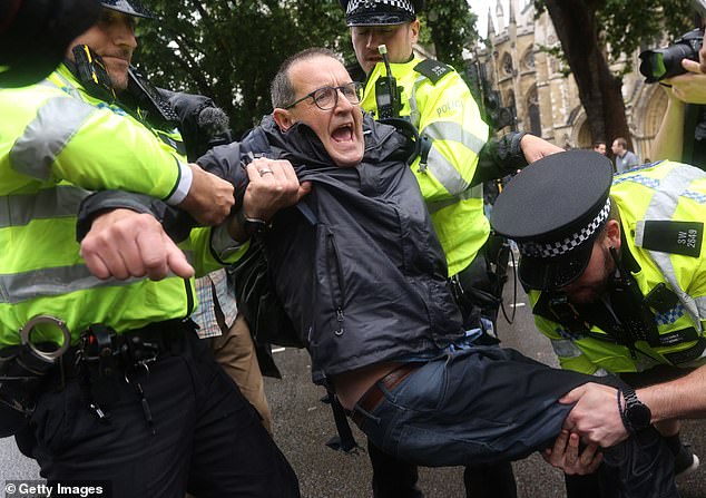 The network of protests, organised by campaign group Defend Our Juries, saw participants hold placards reading: 'I oppose genocide, I support Palestine Action'. Pictured: A protester is carried away by police at the demonstration in London last week