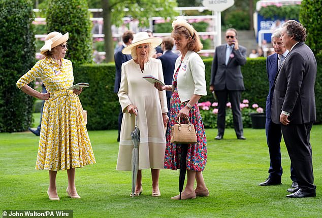 She styled the long-sleeved dress with a matching wide-brimmed hat, and carried an umbrella to shield from any impending rain