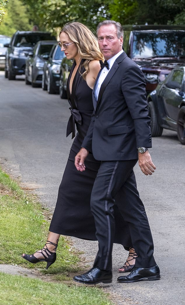 A couple cutting a fashionable shape in coordinated black outfits make their way into the event