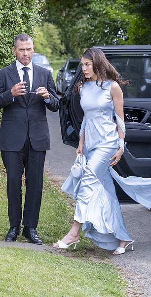 A wedding attendee arrives in a chic satin gown