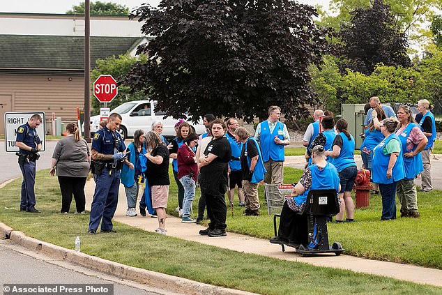 Michigan State Police officers talk to employees near the scene after the stabbing incident