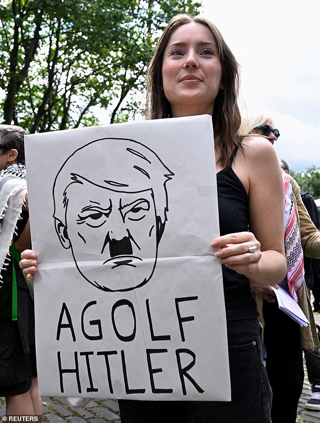 An anti-Trump demonstrator holds a placard during a rally organized by the campaign group Stop Trump Coalition in Edinburgh