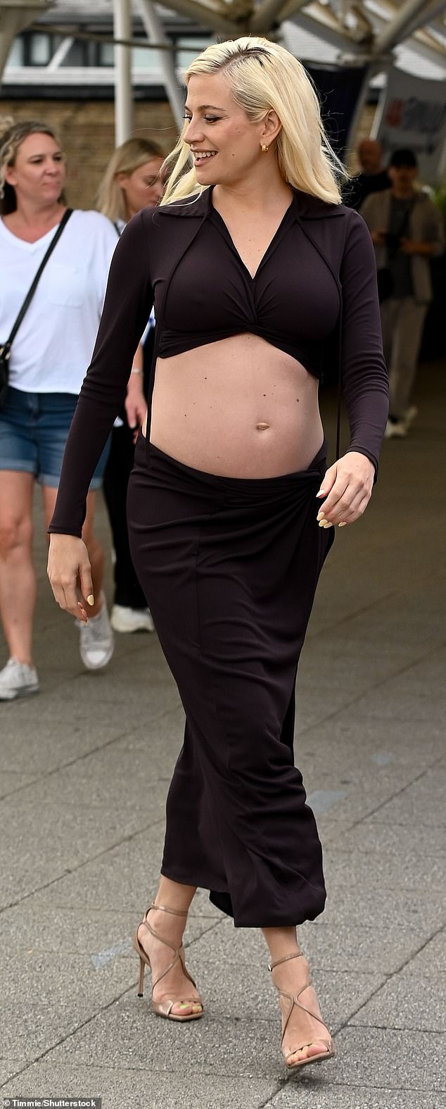 Pixie looked sensational as she showed off her skin and flashed a glimpse at her blossoming belly. Pixie styled her outfit with a pair of strappy black heels and added some delicate gold earrings to her look
