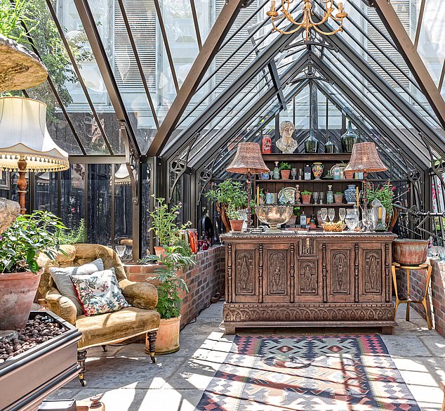 In this Nelly Hall-designed greenhouse, a vintage console is turned into a bar station that serves coffee by day and cocktails by night. Mismatched chairs and lampshades create an informal feel. For a similar wooden console, try vinterior.co.