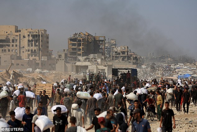 Palestinians carry aid supplies that entered Gaza through Israel, in Beit Lahia in the northern Gaza Strip
