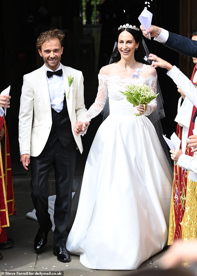 The newlyweds couldn't look happier as they walked out hand-in-hand as white confetti fell on them after the ceremony