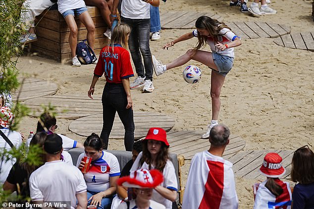 Two football fans were spotted having a kick about as they waited for the match to start in Basel