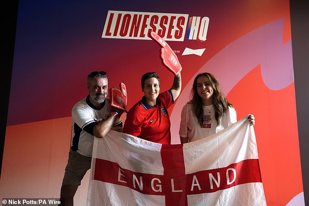 England fans pose for photographers at the fan zone, titled the 'Lionesses HQ' ahead of the final