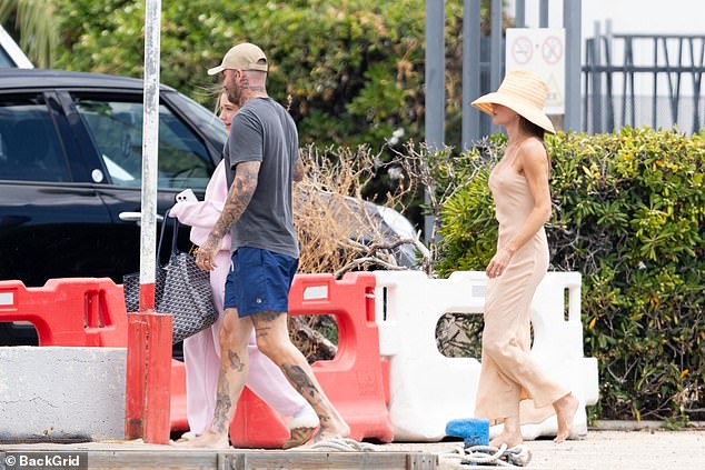 Victoria cut a stylish figure in her cream satin dress and a matching straw hat as she and David headed into the town with their daughter Harper