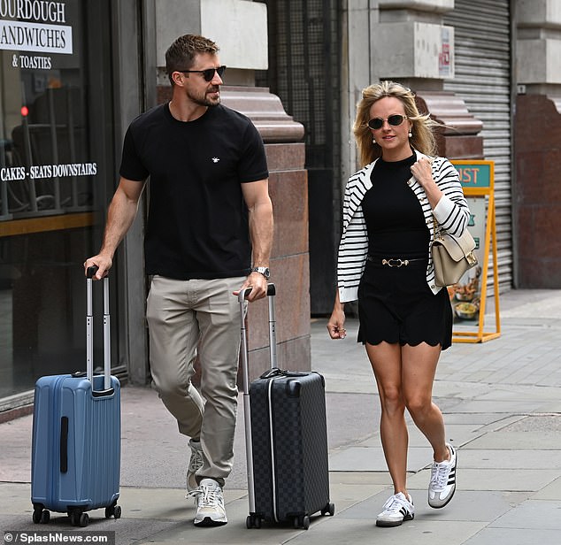 The TV star, dressed in a black mini dress with a striped blazer and white Adidas trainers, looked happy and relaxed as the couple kissed while wheeling their luggage from the hotel