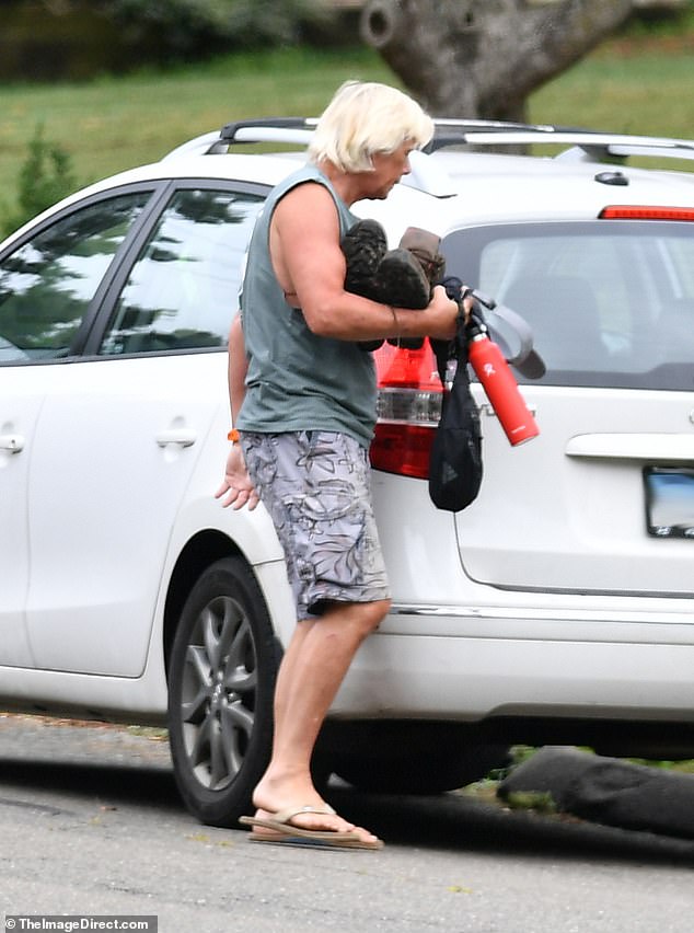 The '80s heartthrob looked as if he was dressed for a day at the beach with a gray¿green tank top and gray floral-patterned Hawaiian-style cargo shorts, along with beige flip flops