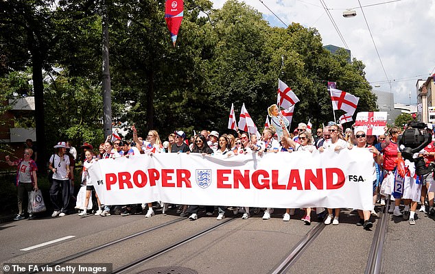 England fans hold up a 'Proper England' banner as they participate in the fan walk to the stadium prior to the game