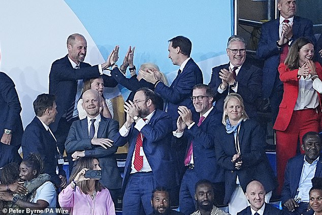 In one picture, William and FA chair Debbie Hewitt do a double high-five over Charlotte standing between them, who looks on smiling at the joyful moment (pictured)