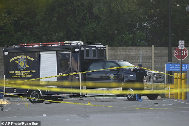 Law enforcement officers are seen stationed outside a Walmart where several people were stabbed in a violent attack Saturday, July 26, 2025, in Traverse City
