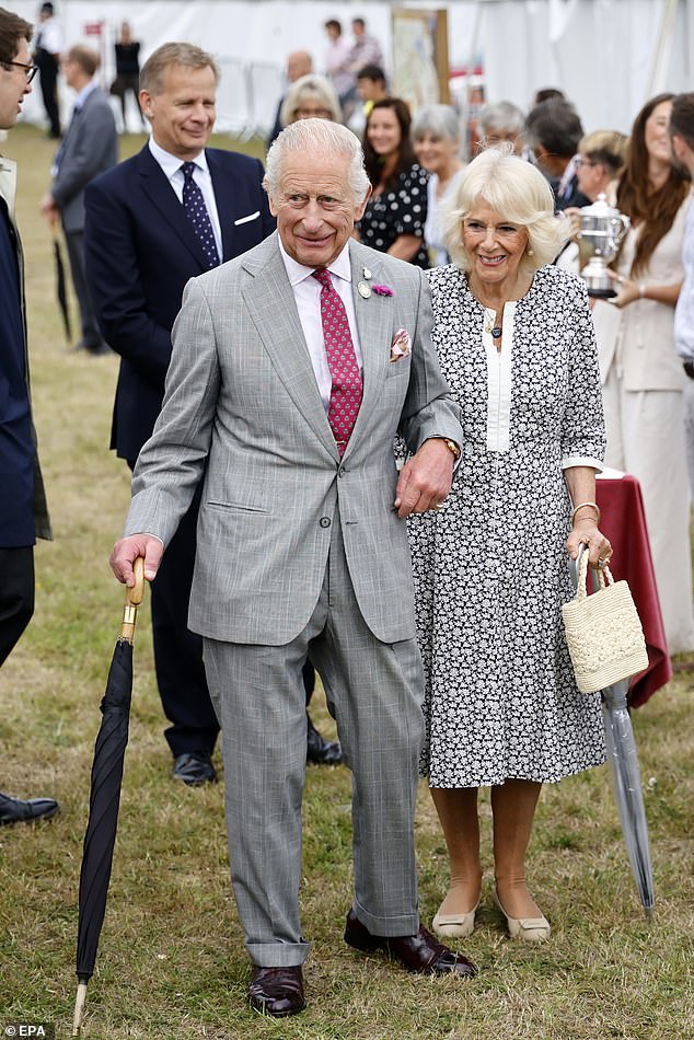 The royal couple were dressed smartly but looked relaxed, carrying their own umbrellas as they met with members of the public and shook hands with those who lined up to greet them