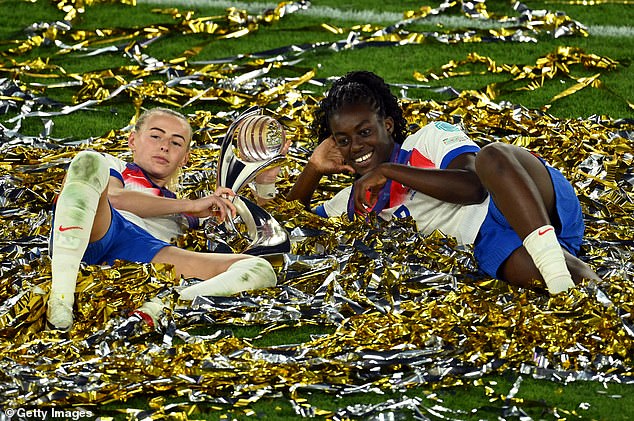 Chloe Kelly and Michelle Agyemang of England celebrate with the UEFA Women's Euro trophy while laying in ticker tape