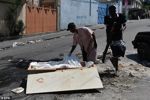 A man collects the remains of a person killed and left in the streets