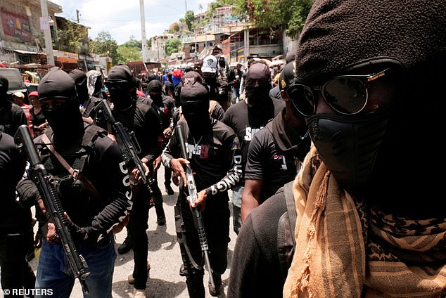 Armed men wield guns as they protest against Haiti's insecurity last month