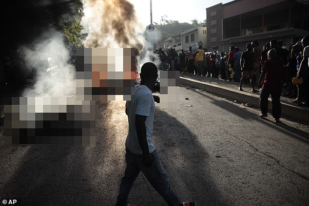 Bystanders watch on as a group of suspected gang members are burned alive by an angry mob