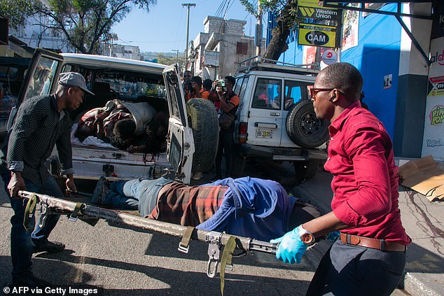 Paramedics carry the body of a man who was killed by gang members in scenes witnesses say was reminiscent of a violent Hollywood movie