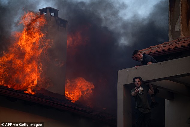 Residents struggle to climb down from a building engulfed in flames in Kryoneri on Saturday