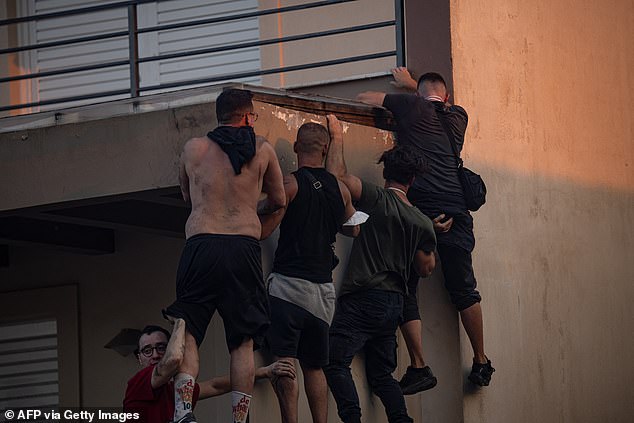 Locals in Kryoneri climb down walls as blazes break out around them