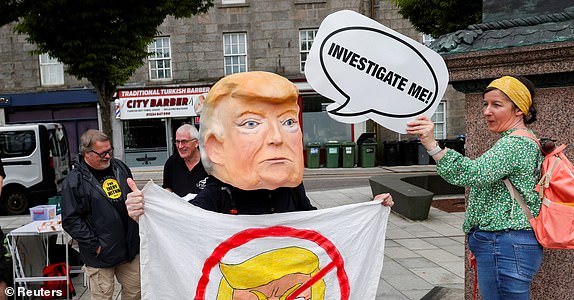 An anti-Trump demonstrator wears a papier-mache head depicting U.S. President Donald Trump during a rally organised by the campaign group Stop Trump Coalition, protesting the visit of U.S President Donald Trump, in Aberdeen, Scotland, Britain, July 26, 2025. REUTERS/Russell Cheyne