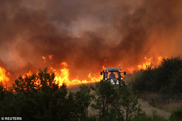 A tractor cuts a fireline as wildfire rages on in the settlement of Beledie Han, Bulgaria