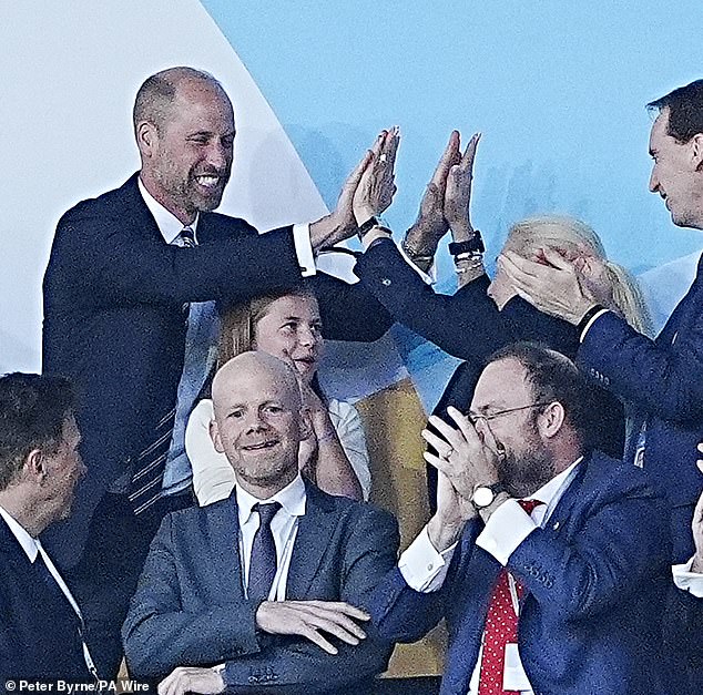 In one picture, William and FA chair Debbie Hewitt do a double high-five over Charlotte standing between them, who looks on smiling at the joyful moment (pictured)