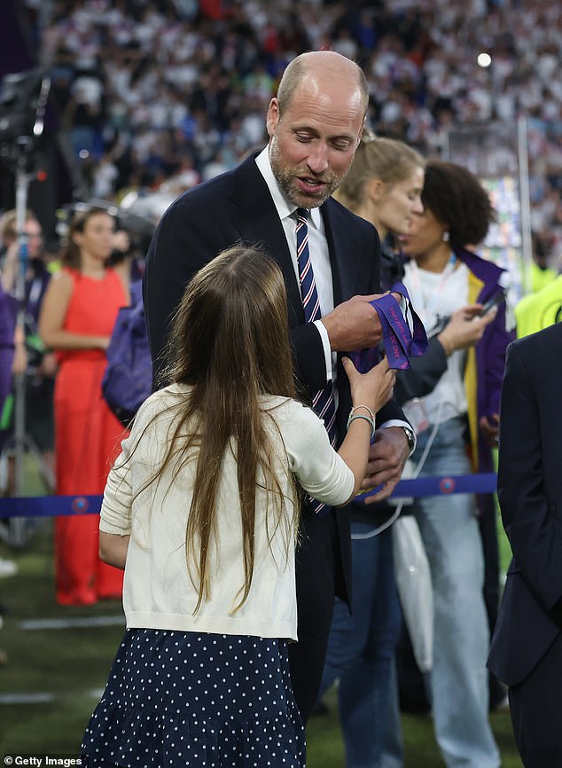 In one image, an amused William looks down at his daughter, who reaches out to touch the medals. In fact, the father seems almost to have to hold them back from Charlotte, whose excitement at the Lionesses' win clearly just could not be contained (pictured)