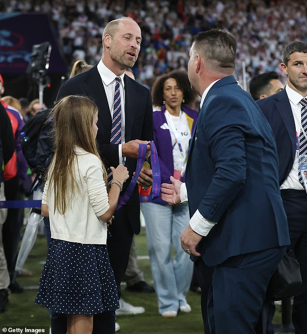 And in a sweet moment (pictured), the Prince was given two winners medals to keep after the presentation - and starstruck Charlotte could not wait to get a proper look at them