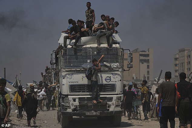 Palestinians carry sacks of flour unloaded from a humanitarian aid convoy that reached Gaza City from the northern Gaza Strip, Sunday, July 27, 2025